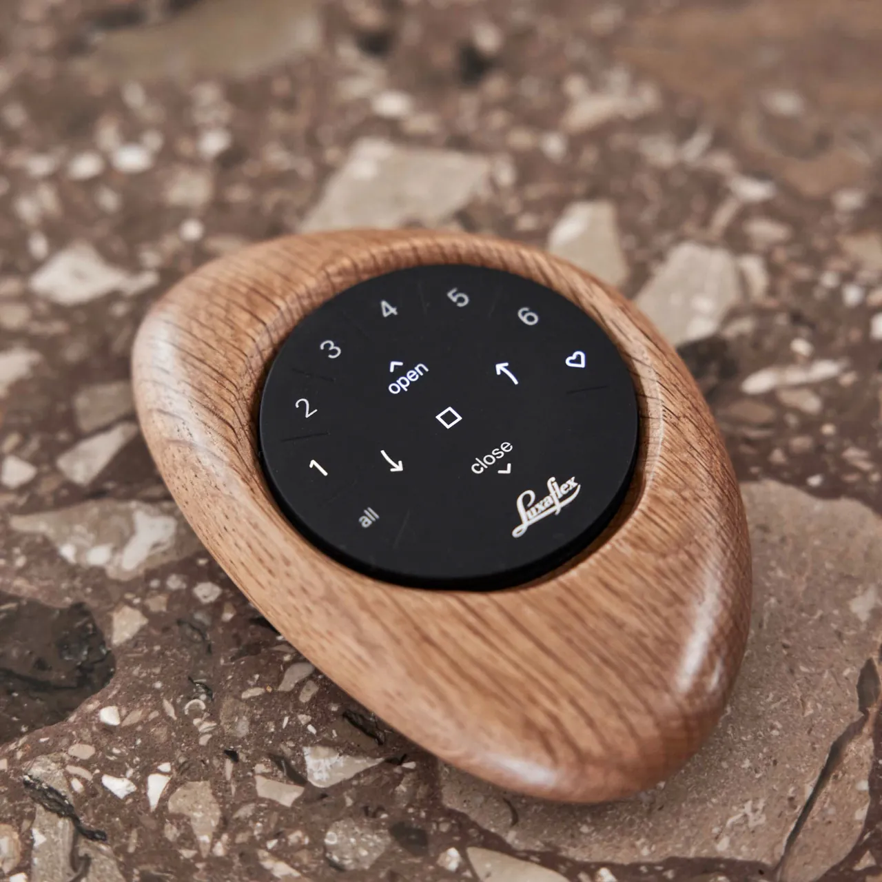 Luxaflex Pebble afstandsbediening in een eiken houder op terrazzo