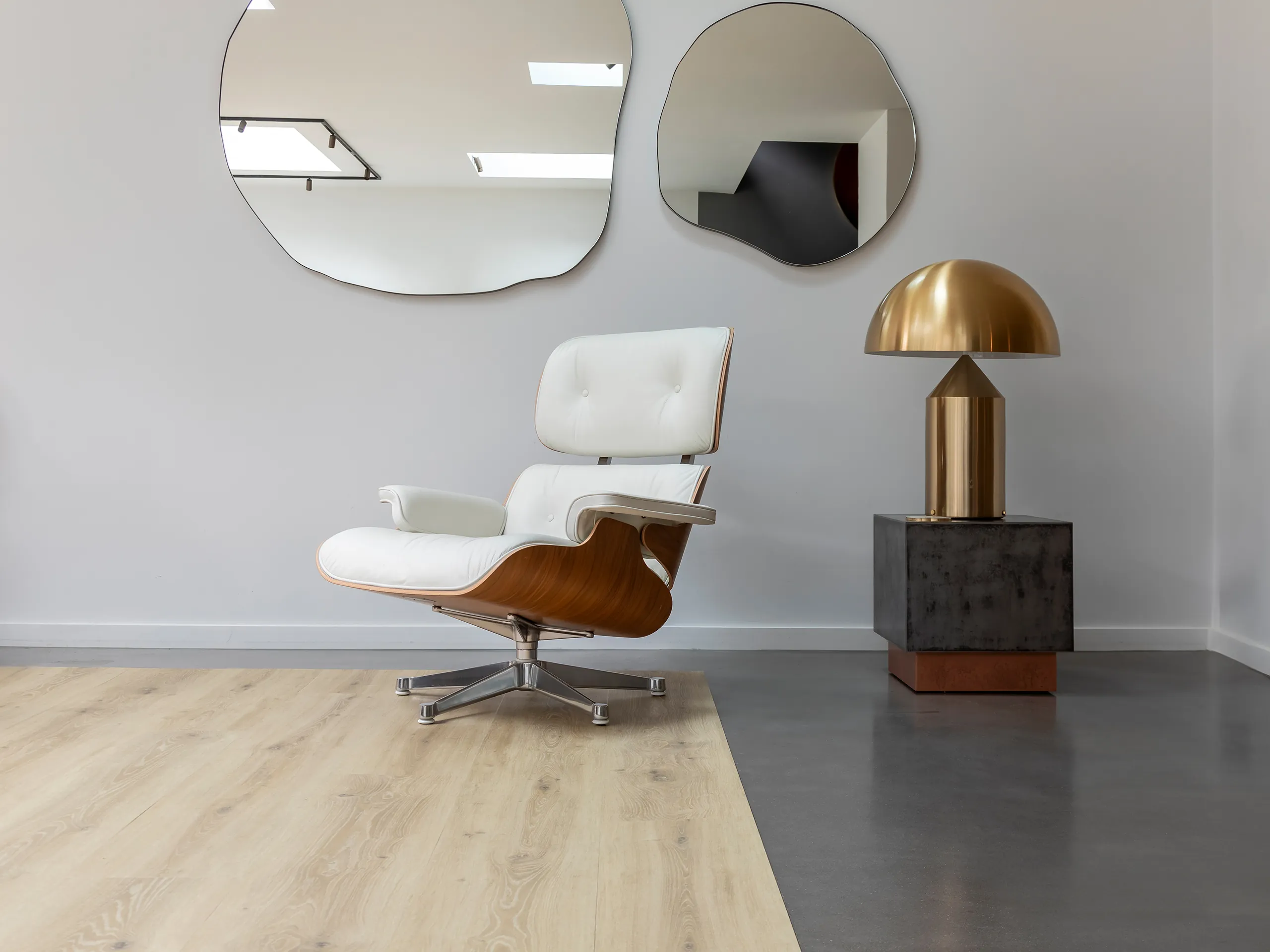 PVC vloer Montinique Chamonix XL Plank in licht eiken met een Eames-stoel.