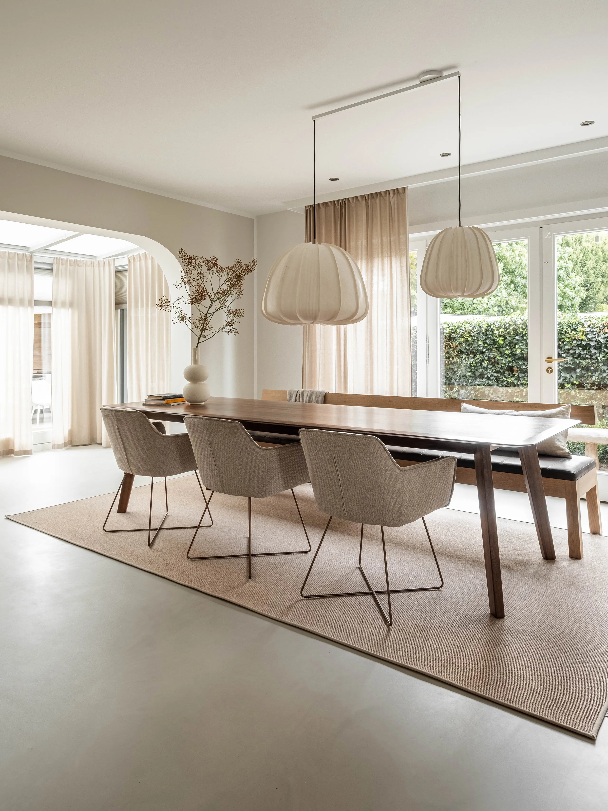 Jabo Carpets vloerkleed in zandbeige onder een eettafel met stoelen op het kleed.