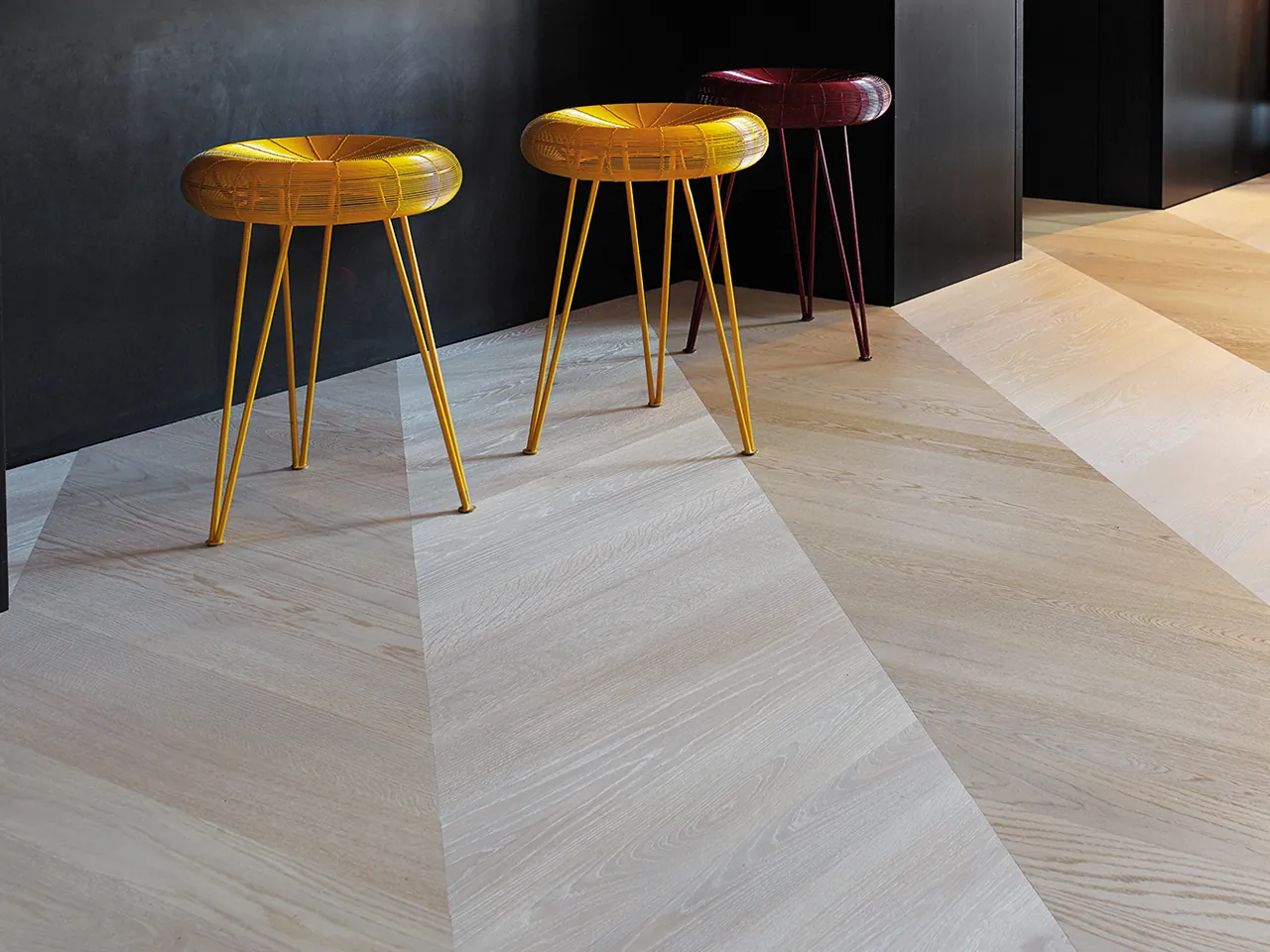 Bauwerk Formpark Rombico eiken parket in ruitpatroon Oak Farina met gele krukken.