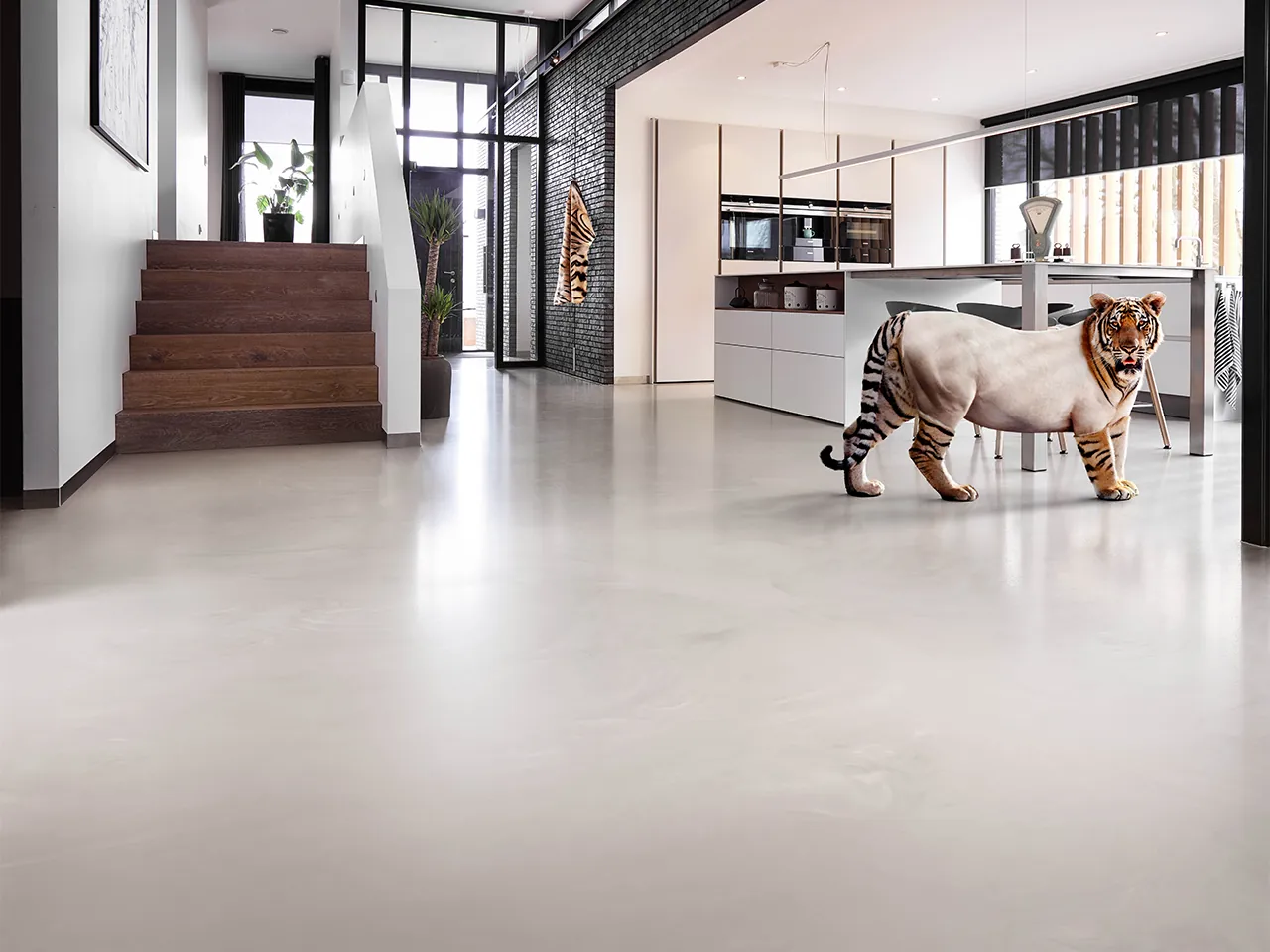 Arturo PU gietvloer in grijze betonlook, naadloos door een open loft met kookeiland.