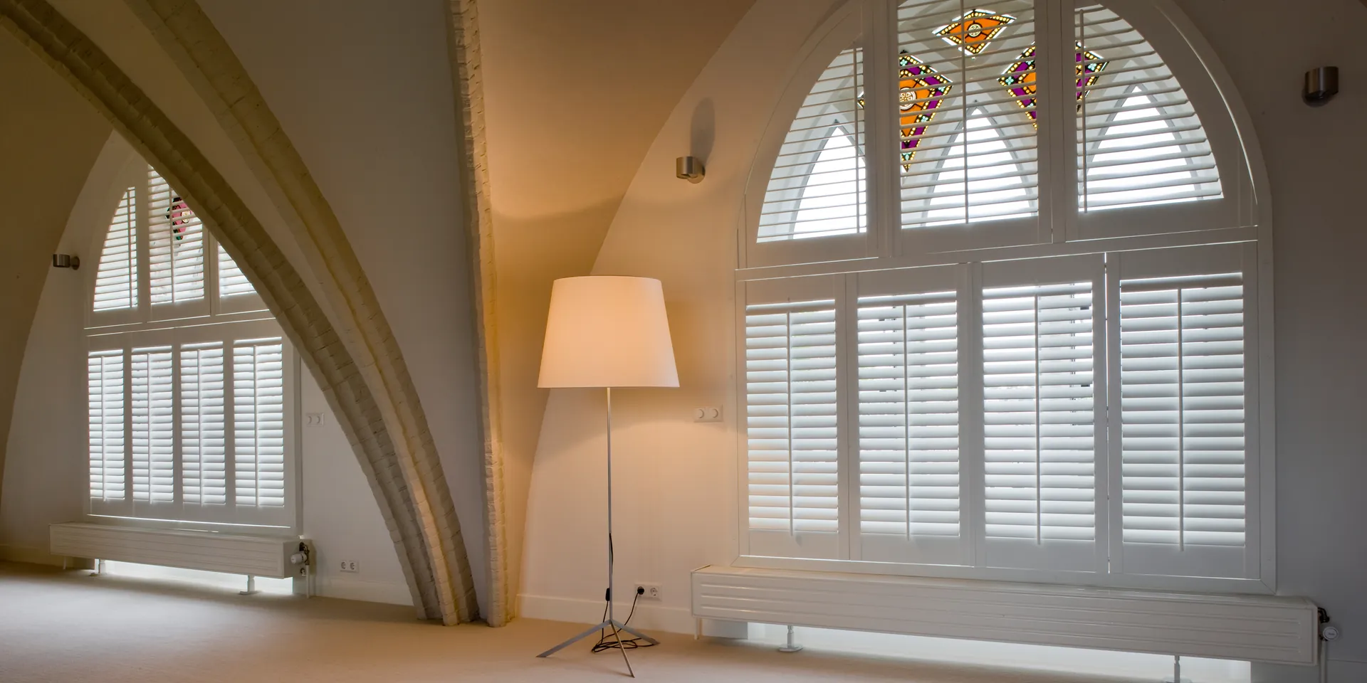 JASNO shutters in wit in een toograam met glas-in-lood, lamellen volgen de boog.