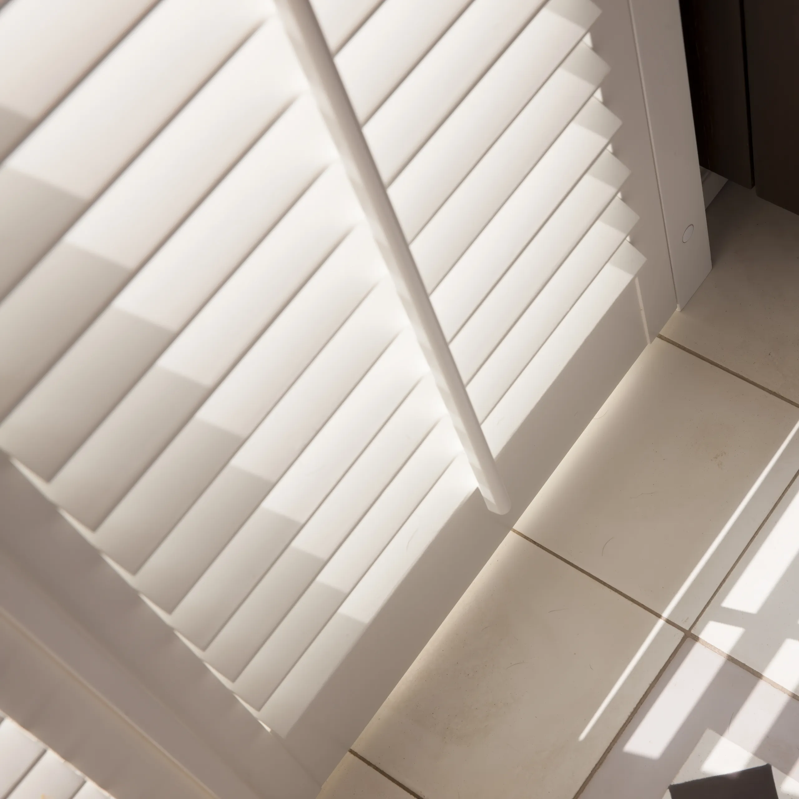 JASNO shutters met 76 mm lamel en verticale bedieningslat, wit, van bovenaf gezien.