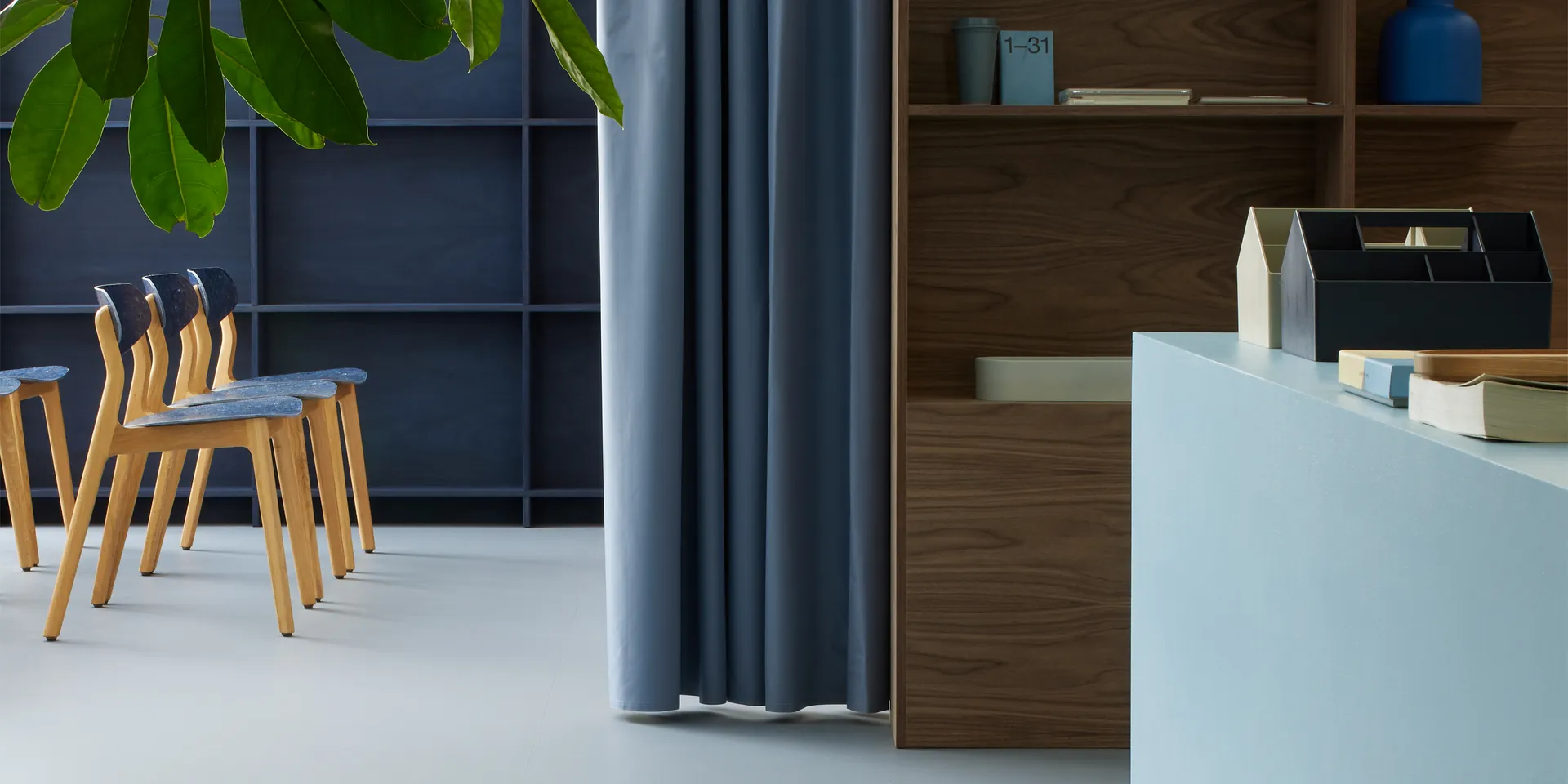 Forbo Marmoleum Cocoa Indigo Milk linoleum in zacht grijsblauw in een lichte werkruimte.