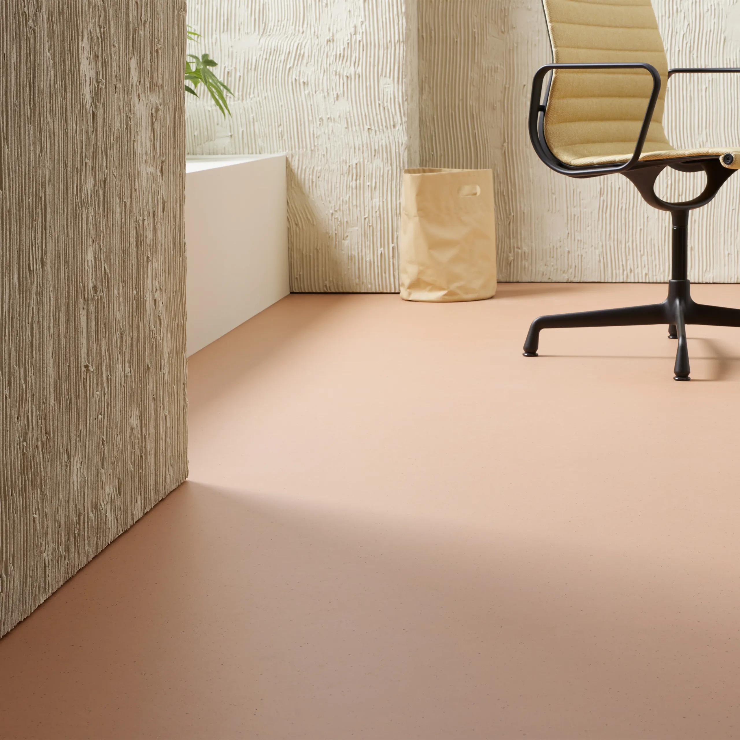 Forbo Marmoleum Cocoa Salted Caramel linoleum in warm karamelroze langs een houtwand.