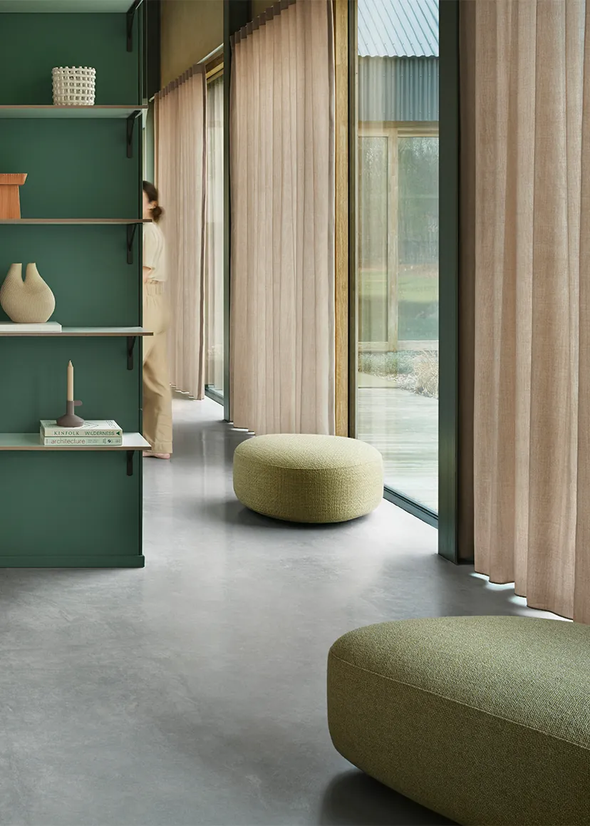 De Ploeg gordijnen Audo in warme blush tint floor-to-ceiling in modern interieur met groene wand en betonvloer